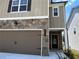 Close-up of the home's exterior highlighting the stone accents, siding, and the two-car garage at 258 Station Overlook Dr, Auburn, GA 30011