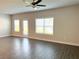 Spacious living room with wood-look flooring, multiple windows, and a door to the exterior at 258 Station Overlook Dr, Auburn, GA 30011