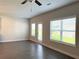 Bright living room featuring wood-look flooring, three windows, and a door leading to the outside at 258 Station Overlook Dr, Auburn, GA 30011
