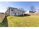 Expansive, well-maintained backyard bordered by a wooden fence, with a view of the home's exterior at 4502 Lake Park Dr, Acworth, GA 30101