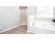 Bright bathroom featuring a glass-door shower, soaking tub under a window, and modern fixtures at 4502 Lake Park Dr, Acworth, GA 30101
