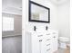 The white bathroom boasts a double vanity with black hardware, tiled backsplash, and modern fixtures at 4502 Lake Park Dr, Acworth, GA 30101
