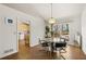 Bright dining room featuring hardwood floors and an elegant light fixture with adjacent access to the kitchen at 877 Old Farm Walk, Marietta, GA 30066