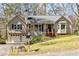 Charming split-level home featuring a two-car garage, inviting front porch, and manicured lawn at 877 Old Farm Walk, Marietta, GA 30066