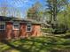 A brick house with a covered patio, a grassy lawn, and a chain link fence for security and partial shade at 251 Banberry Se Dr, Atlanta, GA 30315