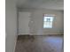 Cozy living room features neutral carpet, a white door, and a window at 251 Banberry Se Dr, Atlanta, GA 30315