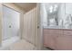 Bright bathroom with a pink vanity, marble countertop, and a shower with a white curtain at 5780 Riverwood Dr, Sandy Springs, GA 30328
