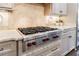 Close-up of a chef's kitchen with a Wolf range and stylish backsplash and modern countertops at 5780 Riverwood Dr, Sandy Springs, GA 30328