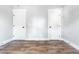 A freshly painted empty bedroom with two white doors with black hardware and wood-look flooring at 661 Inglewood Se Dr, Smyrna, GA 30080