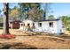 View of a cozy single-story home with a classic white exterior, front porch, and landscaping at 661 Inglewood Se Dr, Smyrna, GA 30080