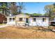 Charming single-story house featuring a bright white exterior, blue door, and a cozy front porch at 661 Inglewood Se Dr, Smyrna, GA 30080