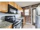 Kitchen with appliances, granite countertops, brick accent wall and neutral flooring at 561 Formwalt Sw St # 6, Atlanta, GA 30312