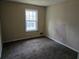 This carpeted bedroom features a window overlooking the yard and neutral walls at 7508 Asbury Manor Dr, Lithonia, GA 30058