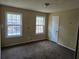 Carpeted bedroom with window, neutral walls, and a white painted door at 7508 Asbury Manor Dr, Lithonia, GA 30058
