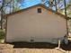 Exterior shot of a home with horizontal siding, exposed foundation, and basement window at 7508 Asbury Manor Dr, Lithonia, GA 30058