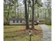 Charming single-story home with a covered carport and an asphalt driveway nestled among mature trees at 7508 Asbury Manor Dr, Lithonia, GA 30058