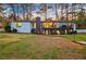 Sprawling backyard featuring a deck, patio, mature trees, and lush lawn at 994 Redbud Sw Ln, Atlanta, GA 30311