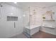 Bright bathroom featuring a glass shower, a freestanding tub, and stylish decorative shelves at 994 Redbud Sw Ln, Atlanta, GA 30311