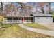 Charming gray home with a welcoming front porch, red door, and manicured lawn offers great curb appeal at 1354 Litchfield Ct, Snellville, GA 30078