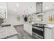 Modern kitchen with white cabinets, stainless appliances, granite countertops, and gray floors at 1354 Litchfield Ct, Snellville, GA 30078