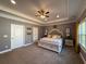 Spacious main bedroom with large windows, tray ceilings, a ceiling fan, and an ensuite bathroom at 197 Buckhorn Dr, Temple, GA 30179