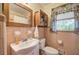 Cozy bathroom featuring a vintage vanity, toilet, and small window with charming curtains at 1122 Byers Sw Dr, Marietta, GA 30060