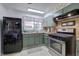 A kitchen featuring green cabinets, stainless steel appliances, and a black refrigerator at 1122 Byers Sw Dr, Marietta, GA 30060