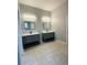 Elegant bathroom with dual vanities, modern lighting, and neutral tile flooring at 135 Yancey Rd, Covington, GA 30014