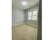 Cozy bedroom with light wood flooring and natural light from a window at 135 Yancey Rd, Covington, GA 30014