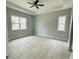 Spacious bedroom with tray ceiling, ceiling fan, and natural light from the two windows at 135 Yancey Rd, Covington, GA 30014