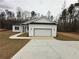 Charming single-story home featuring a white exterior, attached garage, and a well-manicured lawn at 135 Yancey Rd, Covington, GA 30014