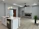Open-concept living area featuring a fireplace, wood-look flooring, and a view of the kitchen island at 135 Yancey Rd, Covington, GA 30014