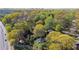 Expansive aerial view of a home surrounded by lush green trees, showcasing the property's privacy and serene setting at 1911 Woodland Hills Nw Ave, Atlanta, GA 30318