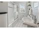 Classic bathroom featuring a shower-tub combo, pedestal sink and floating shelves at 1911 Woodland Hills Nw Ave, Atlanta, GA 30318