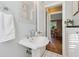 Bright bathroom featuring a pedestal sink with chrome hardware and tile flooring at 1911 Woodland Hills Nw Ave, Atlanta, GA 30318