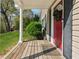 Inviting front porch with a wooden deck, red door, and lush greenery, perfect for relaxing and enjoying the outdoors at 1911 Woodland Hills Nw Ave, Atlanta, GA 30318