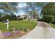Charming home with a well-manicured lawn, colorful flowers, and a long driveway, showcasing its curb appeal at 1911 Woodland Hills Nw Ave, Atlanta, GA 30318