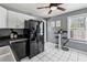 Bright kitchen features white cabinets, black appliances and table with bar stools near a sunlit window at 1911 Woodland Hills Nw Ave, Atlanta, GA 30318