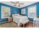 Stylish main bedroom with blue walls, hardwood floors, and lots of natural light at 1911 Woodland Hills Nw Ave, Atlanta, GA 30318