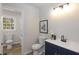 Nicely appointed bathroom with navy vanity, modern faucet, art and tile shower at 1749 Lauranceae Way, Riverdale, GA 30296