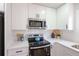 Bright kitchen featuring white cabinets, stainless steel microwave, and quartz countertops at 1749 Lauranceae Way, Riverdale, GA 30296