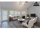 Bright living room features a fireplace, ceiling fan, and large windows with natural light at 223 Gilliam Ct, Locust Grove, GA 30248