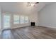 An empty living room featuring a fireplace, ceiling fan, and large windows with natural light at 223 Gilliam Ct, Locust Grove, GA 30248