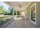 Covered back porch with a ceiling fan and white railing, offering a serene outdoor living space at 5440 Shady Grove Rd, Cumming, GA 30041