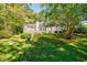 Expansive backyard featuring mature trees, lush green lawn and a white home with a deck at 5440 Shady Grove Rd, Cumming, GA 30041