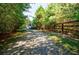 Gravel driveway leading to the home, surrounded by mature trees and a wooden fence at 5440 Shady Grove Rd, Cumming, GA 30041