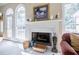 Close up on the fireplace with decorative mantle, large windows and hardwood floors at 5440 Shady Grove Rd, Cumming, GA 30041