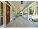 Covered front porch with wood flooring, white columns, and ample space for outdoor seating at 5440 Shady Grove Rd, Cumming, GA 30041