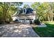Detached two-car garage with white doors and siding surrounded by lush green landscaping at 5440 Shady Grove Rd, Cumming, GA 30041