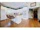 Bright kitchen with white cabinetry, a central island, hardwood floors, and bar stool seating at 5440 Shady Grove Rd, Cumming, GA 30041